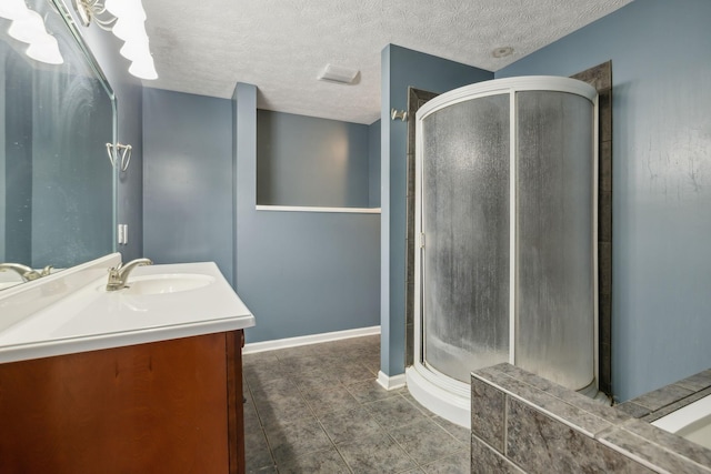 bathroom featuring a textured ceiling, tile patterned flooring, vanity, baseboards, and a shower stall