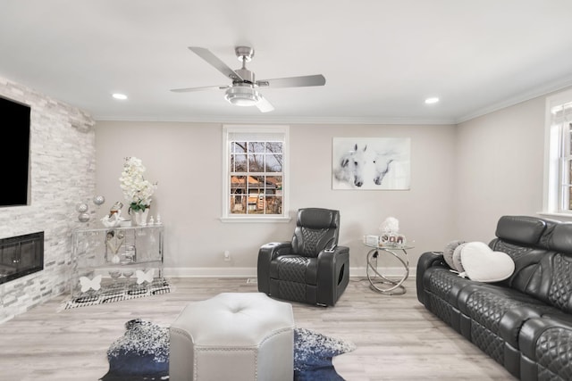 living room featuring ornamental molding, a stone fireplace, and wood finished floors