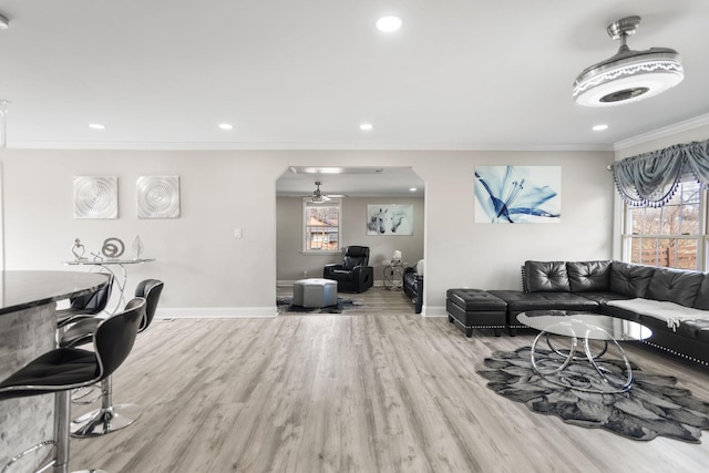 living room with recessed lighting, baseboards, crown molding, and wood finished floors