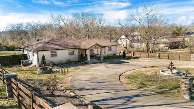 view of front of house featuring aphalt driveway, brick siding, fence, and central air condition unit