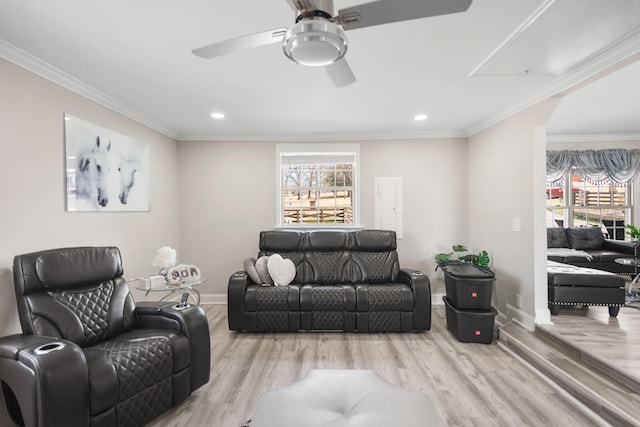 living area featuring a healthy amount of sunlight, ornamental molding, and wood finished floors