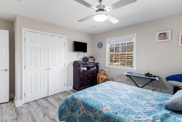 bedroom featuring a closet, ceiling fan, baseboards, and wood finished floors