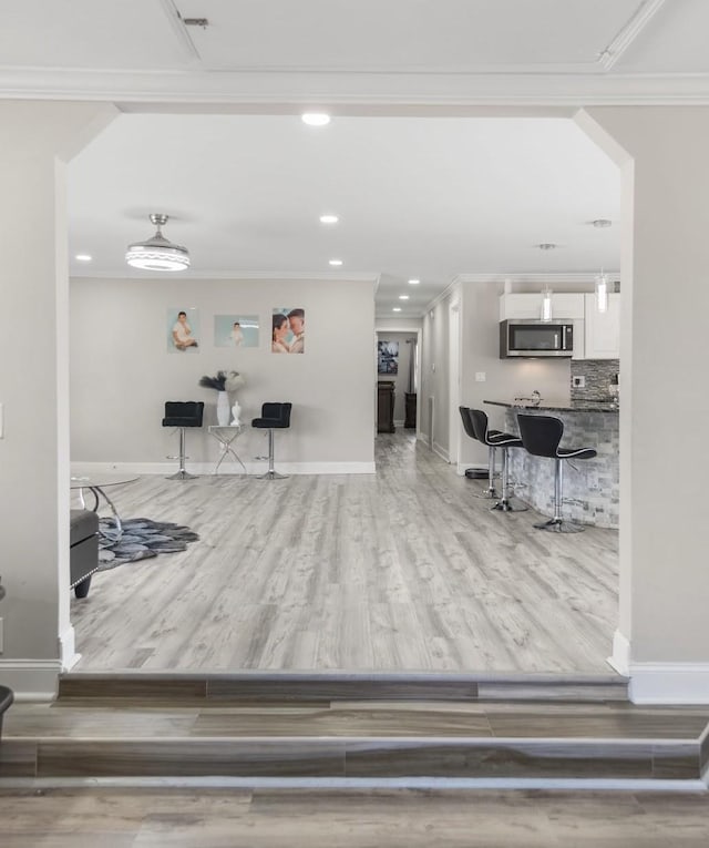 interior space featuring baseboards, wood finished floors, and crown molding