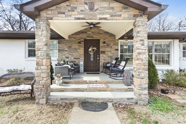 doorway to property featuring covered porch, stone siding, and a ceiling fan