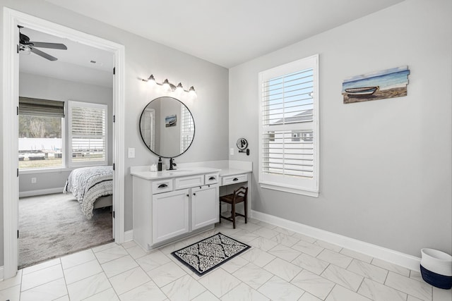 ensuite bathroom with ensuite bath, ceiling fan, baseboards, and vanity