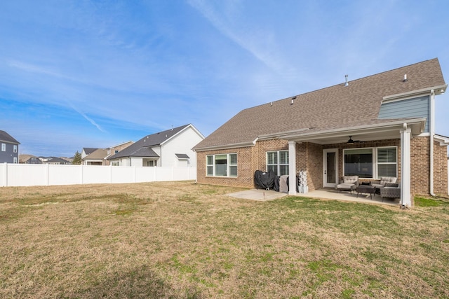 rear view of property with a yard, outdoor lounge area, a patio area, and fence