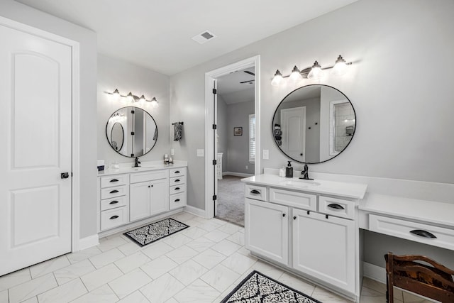 full bath with two vanities, a sink, and visible vents