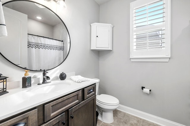 bathroom featuring tile patterned flooring, vanity, toilet, and baseboards