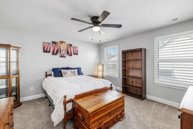 bedroom with visible vents, baseboards, a ceiling fan, and light colored carpet