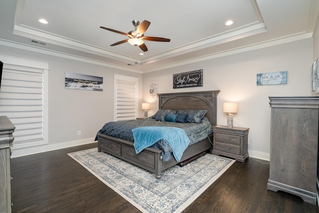 bedroom with dark wood-type flooring, a raised ceiling, visible vents, and baseboards