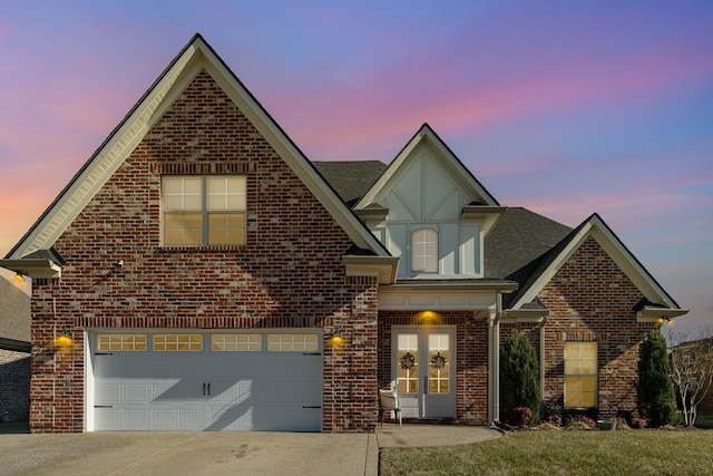 view of front of home with a garage, a shingled roof, brick siding, concrete driveway, and french doors