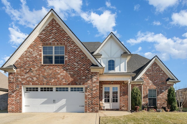 view of front of home featuring a garage, concrete driveway, roof with shingles, french doors, and brick siding