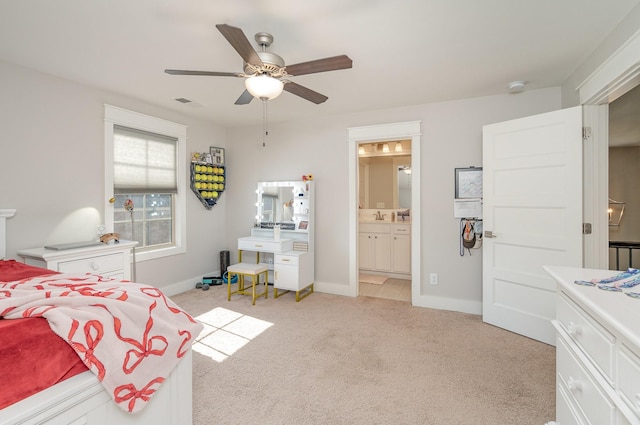 bedroom featuring light carpet, visible vents, baseboards, ensuite bathroom, and a sink