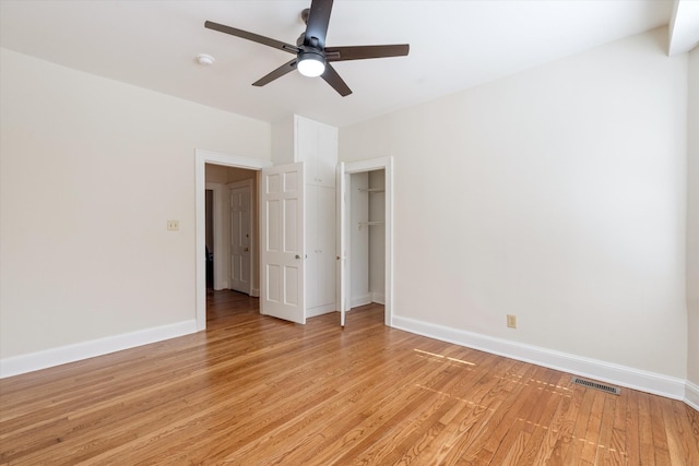 unfurnished bedroom with a ceiling fan, baseboards, visible vents, light wood-style floors, and a closet