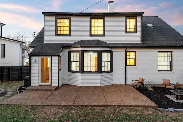 rear view of property featuring a chimney, a patio area, and fence