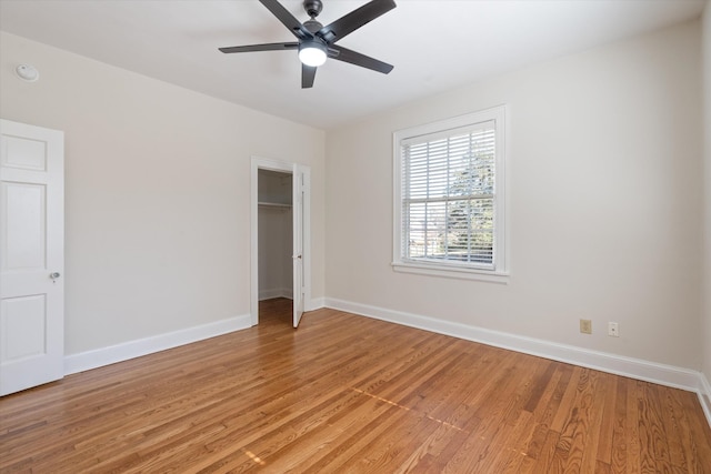 unfurnished room featuring ceiling fan, light wood-style flooring, and baseboards