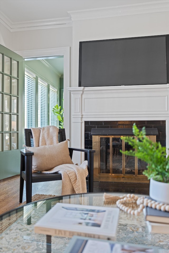 living area with a glass covered fireplace and crown molding