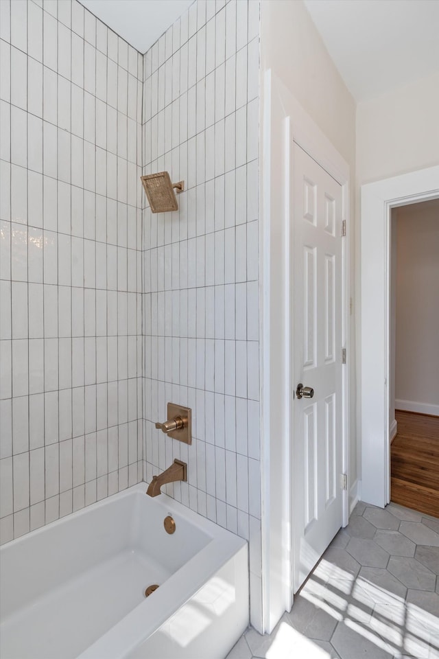 full bath featuring  shower combination, tile patterned flooring, and baseboards