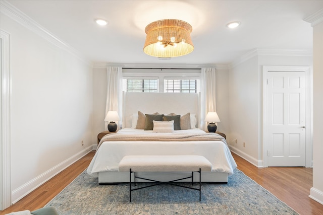 bedroom featuring ornamental molding, wood finished floors, and baseboards