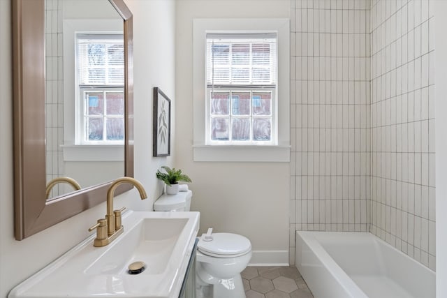 bathroom featuring toilet, vanity, shower / tub combination, baseboards, and tile patterned floors