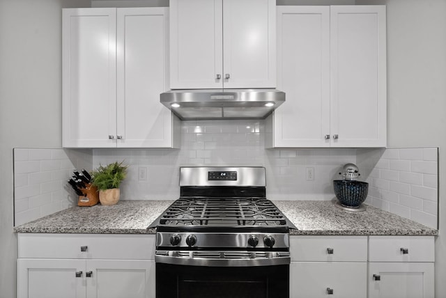 kitchen with white cabinets, backsplash, stainless steel range with gas stovetop, and under cabinet range hood