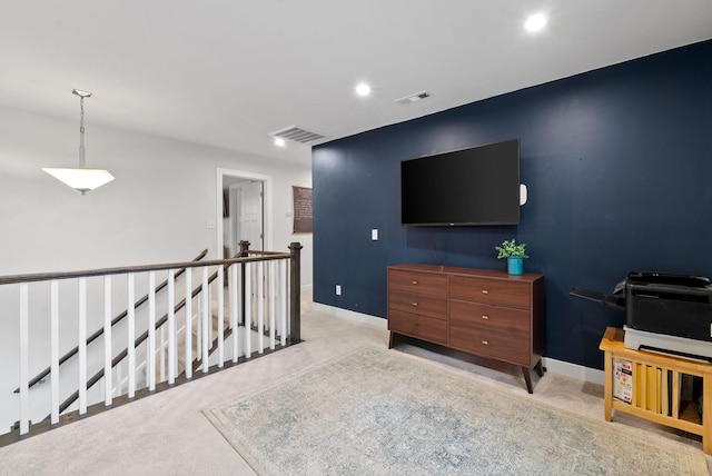 interior space with baseboards, visible vents, and an upstairs landing