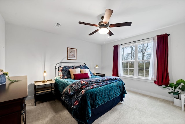 carpeted bedroom featuring a ceiling fan, visible vents, and baseboards