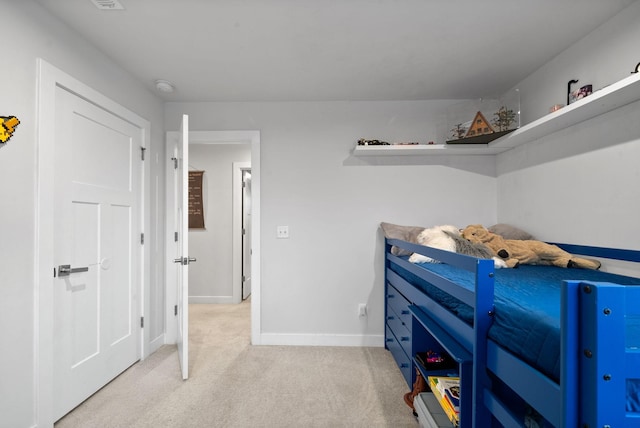 bedroom with baseboards and light colored carpet