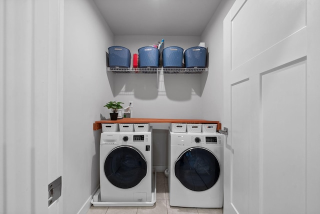 clothes washing area featuring laundry area, washer and clothes dryer, and tile patterned flooring