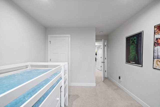 bedroom featuring light carpet and baseboards