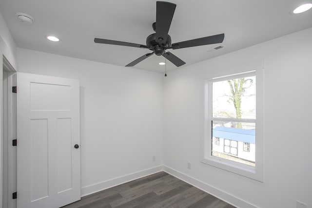 empty room with dark wood-style floors, recessed lighting, and baseboards