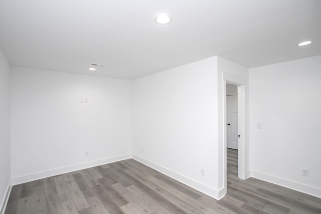 empty room featuring recessed lighting, visible vents, baseboards, and wood finished floors