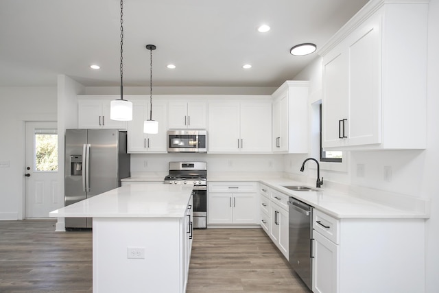 kitchen with light wood-type flooring, white cabinets, stainless steel appliances, and a sink