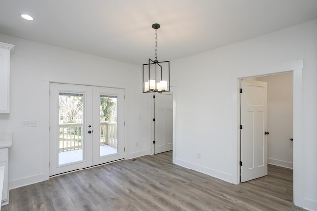 unfurnished dining area with recessed lighting, french doors, baseboards, and wood finished floors