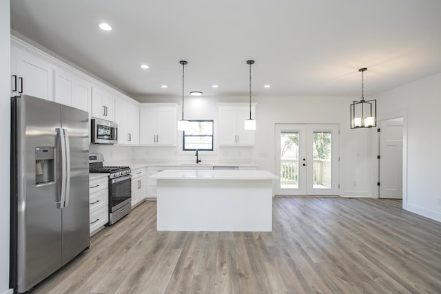 kitchen featuring a sink, light wood-style floors, light countertops, appliances with stainless steel finishes, and a center island