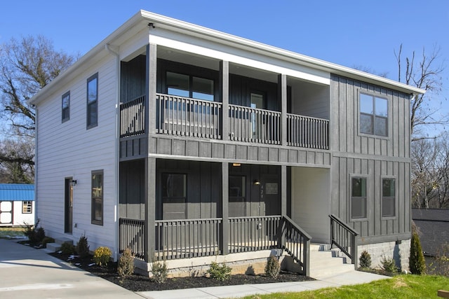 view of property featuring board and batten siding, covered porch, and a balcony