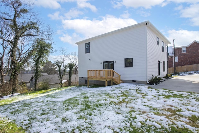 snow covered back of property featuring crawl space, fence, and a wooden deck