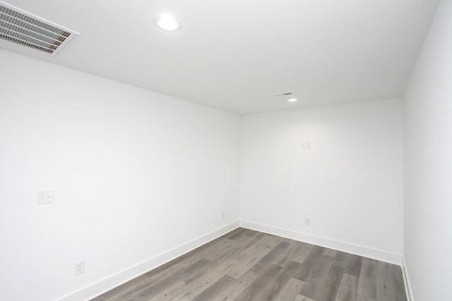 unfurnished room with baseboards, visible vents, wood finished floors, and recessed lighting