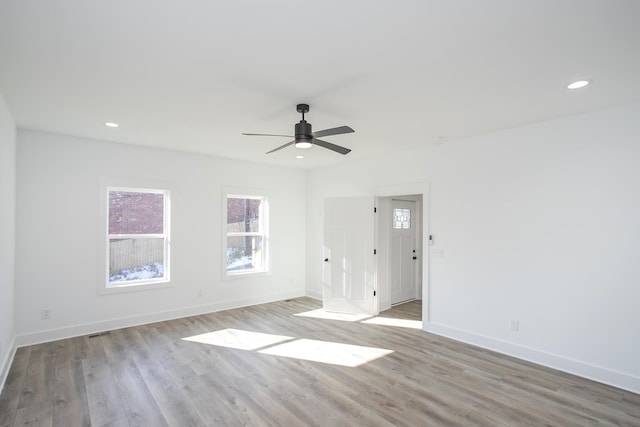 empty room featuring light wood-type flooring, baseboards, and recessed lighting