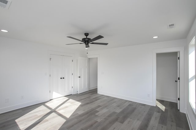 unfurnished bedroom featuring a closet, dark wood-style flooring, and visible vents