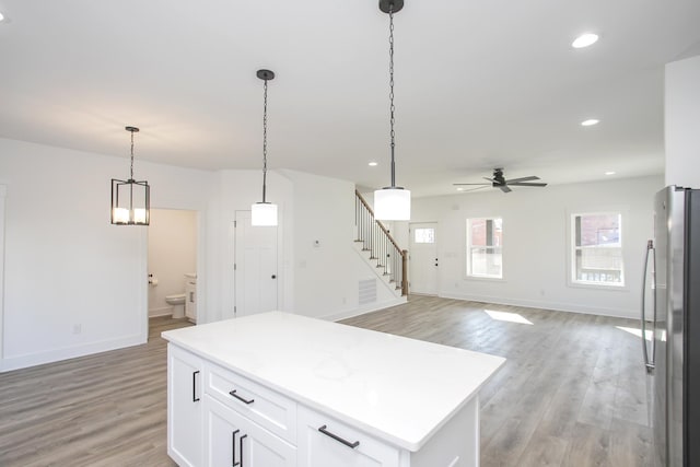 kitchen with recessed lighting, white cabinets, freestanding refrigerator, light wood finished floors, and pendant lighting