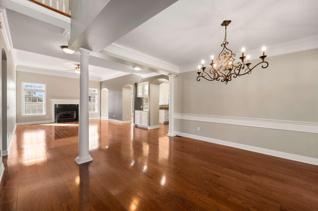 unfurnished living room featuring wood-type flooring, a fireplace, ornate columns, and ceiling fan