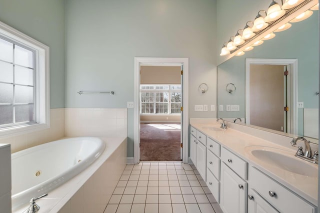 full bathroom with a jetted tub, tile patterned flooring, double vanity, and a sink