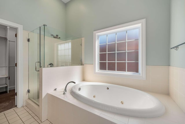 bathroom with a whirlpool tub, a shower stall, and tile patterned flooring