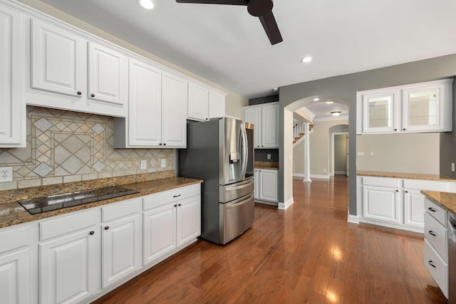 kitchen with arched walkways, white cabinets, a ceiling fan, stainless steel fridge with ice dispenser, and black electric stovetop