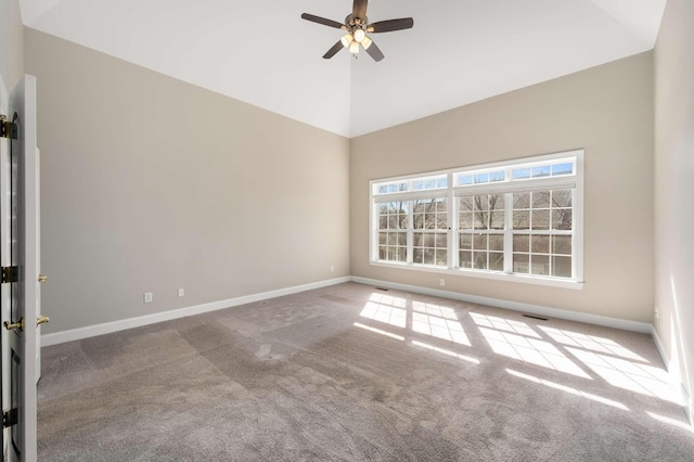 carpeted spare room with vaulted ceiling, ceiling fan, and baseboards