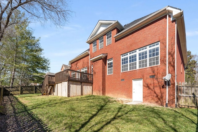 exterior space featuring a lawn, stairway, fence, a deck, and brick siding