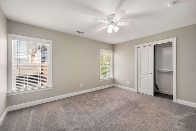 unfurnished bedroom with carpet floors, a closet, visible vents, a ceiling fan, and baseboards