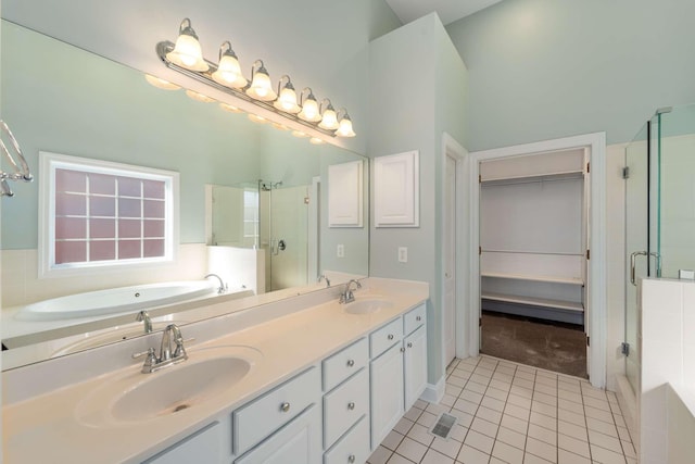 bathroom featuring tile patterned flooring, a garden tub, a sink, and a shower stall