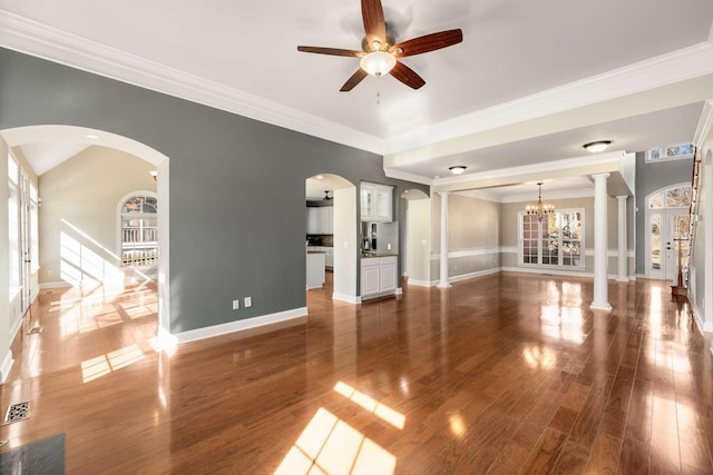 unfurnished living room featuring crown molding, baseboards, and wood finished floors